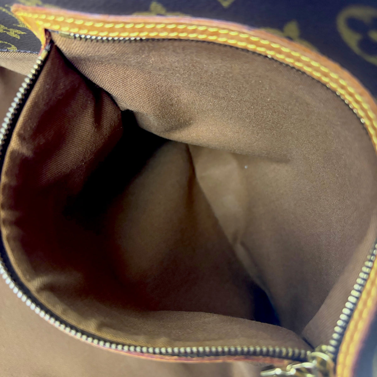 Monogram tote bag interior with beige fabric lining and side wall detail