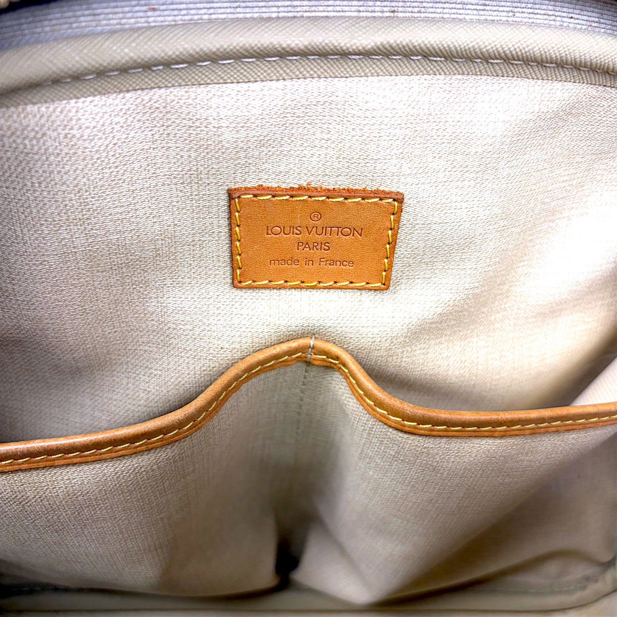 Beige fabric interior with Louis Vuitton Paris label and stitched leather trim