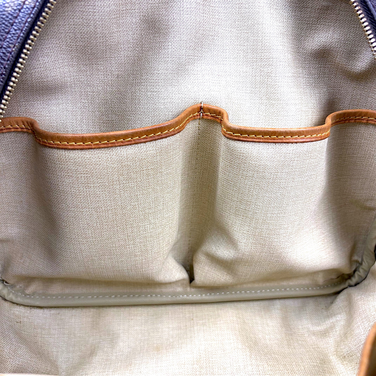 Beige fabric interior base with stitched leather trim and inner seam detail