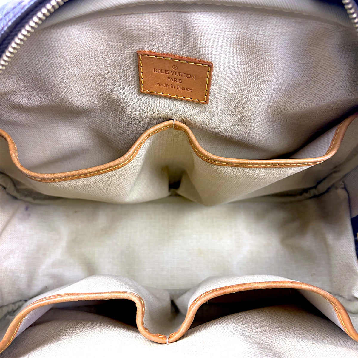 Leather monogram bag interior with tan lining and orange trim
