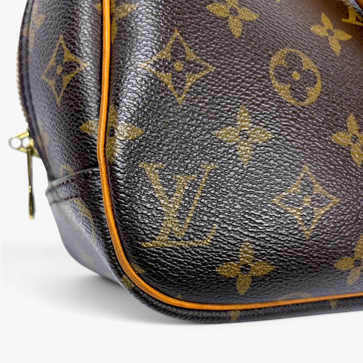 Brown monogram leather side with orange edge piping and zipper pull
